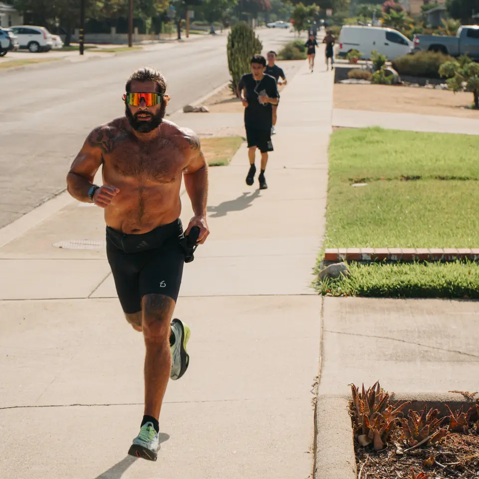 Bearded runner in bright sunglasses pushing the pace through a Glendora neighborhood