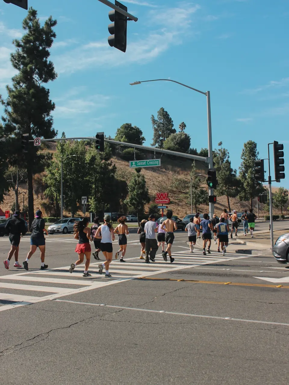 Runners crossing the street at Sunset Crossing in Diamond Bar under blue skies