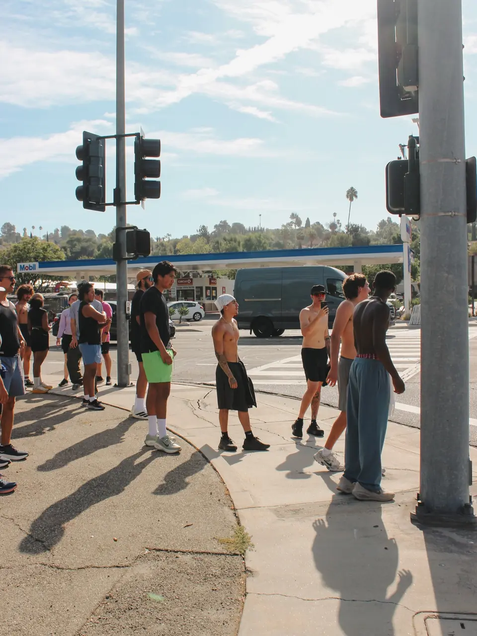 Shirtless runners catching their breath at the corner after the run