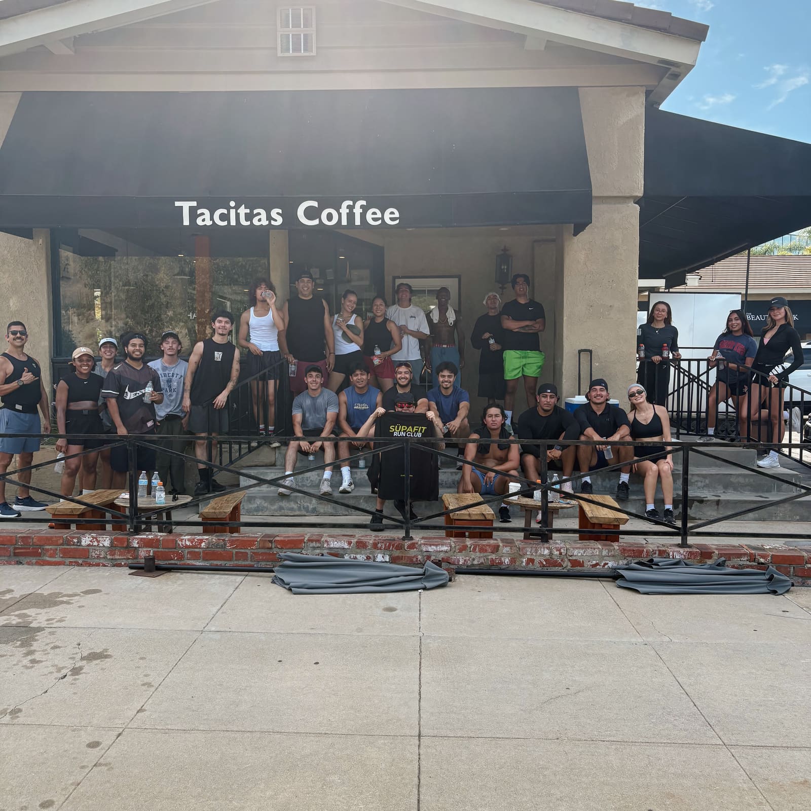 Full crew posing with a SÜPAFIT Run Club sign at Tacitas Coffee in Diamond Bar