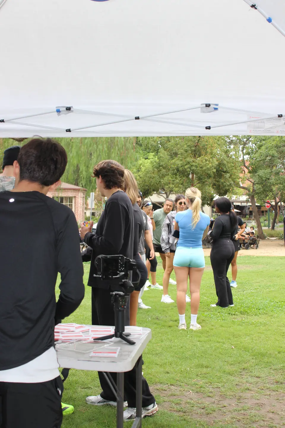 Crew checking in at the welcome table under a white pop up tent