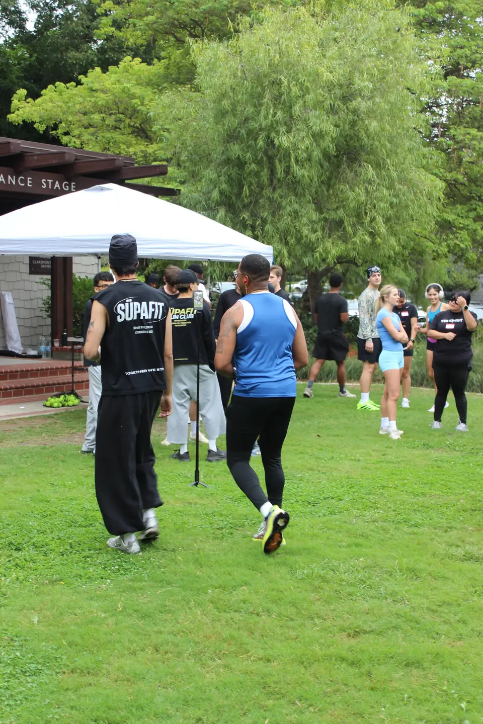 Runners arriving on the grass near the community stage at Shelton Park in Claremont
