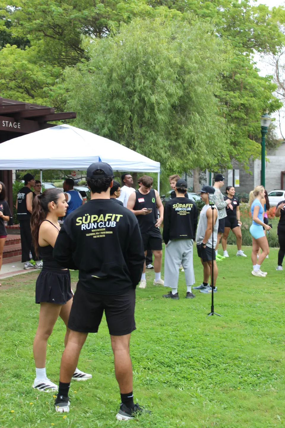 Runner in a SÜPAFIT Run Club long sleeve watching the crowd gather before the run