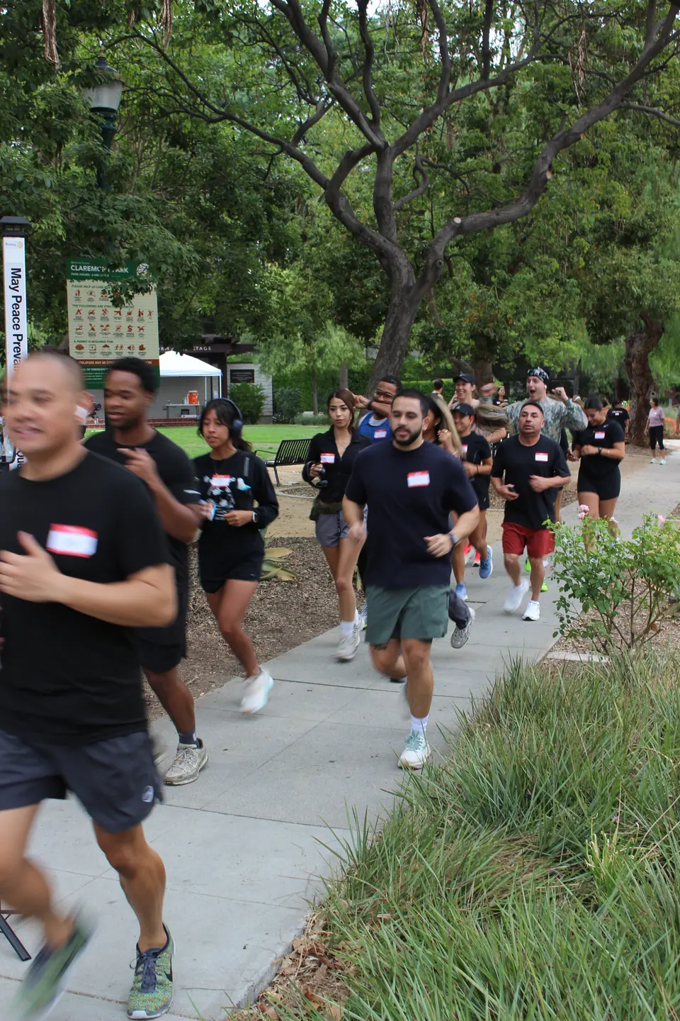 Big pack of runners with name tags heading out of Shelton Park in Claremont